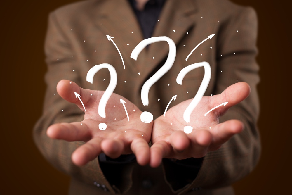 Young business man in suit presenting hand drawn question marks